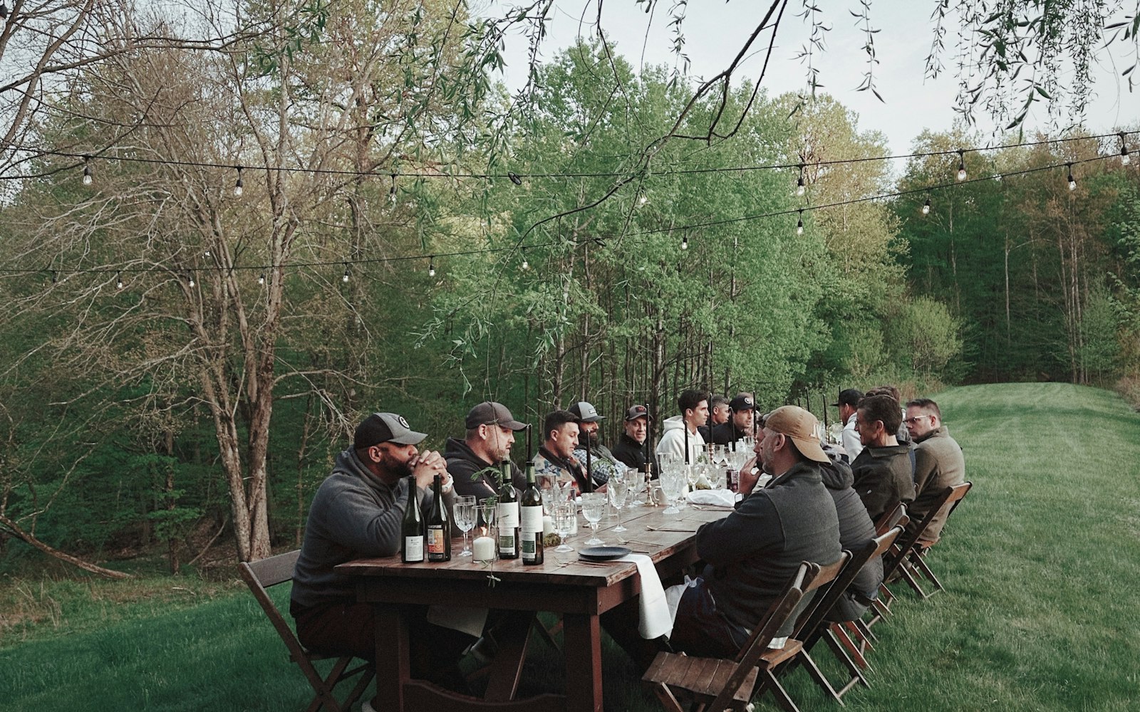Repas entre amis en plein air avec guirlandes